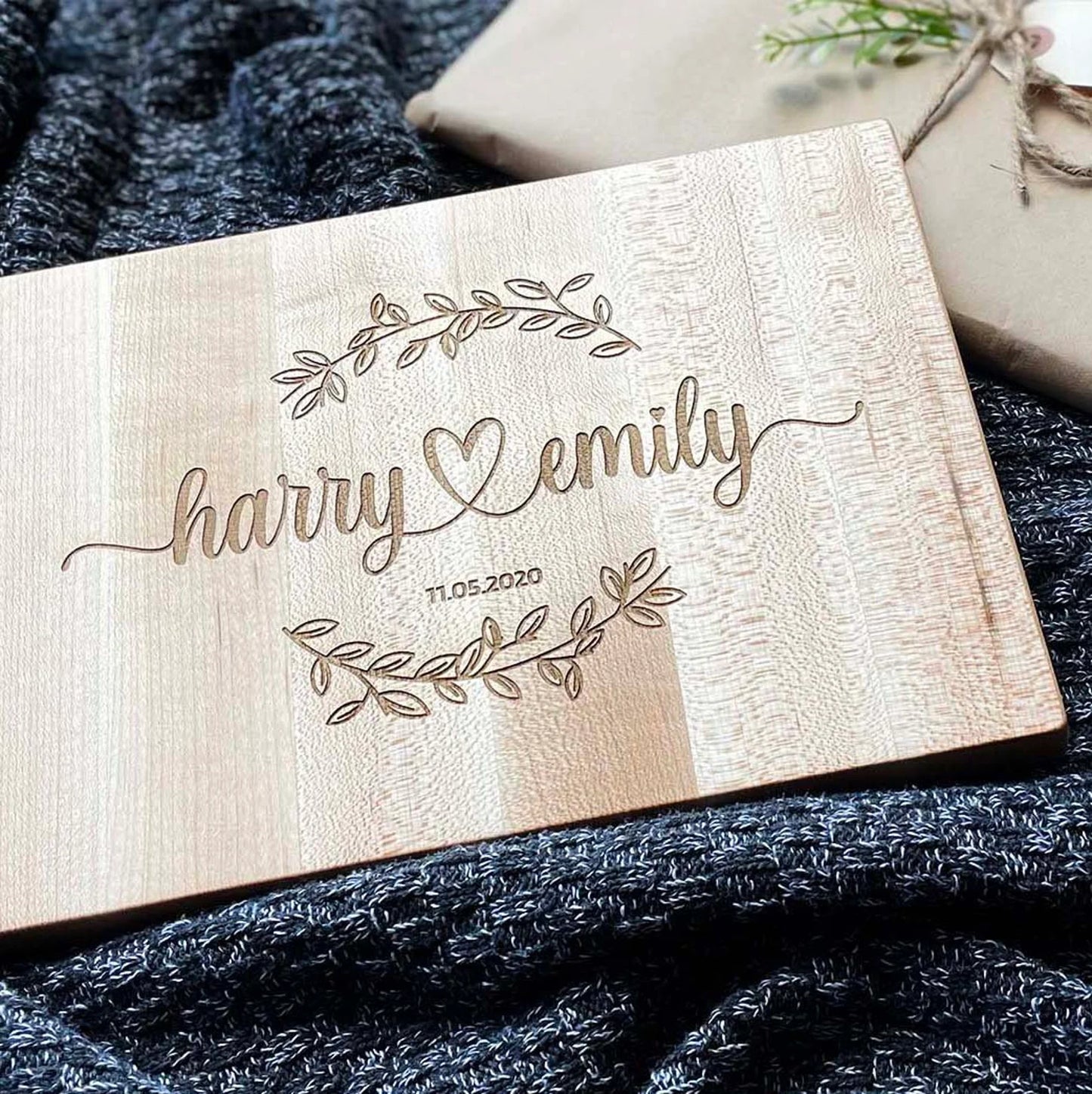 Wooden plaque with engraved names 'Harry' and 'Emily' on a textured fabric background
